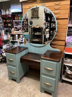 a blue vanity with mirror and drawers in a store