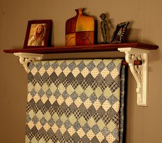 a quilt hanging on a shelf in a room