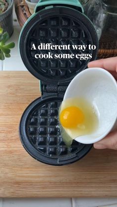 a person holding an egg in a waffle iron