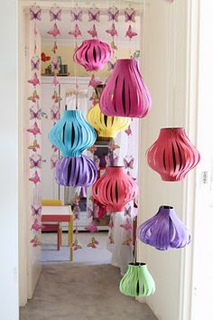 colorful paper lanterns hanging from the ceiling in a hallway