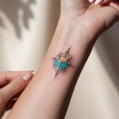 a woman's arm with a small star tattoo on her left wrist and an arrow in the middle