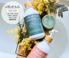 two bottles of hand lotion sitting next to each other on a table with yellow flowers