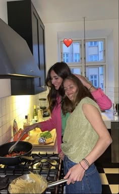 two women are cooking in the kitchen together