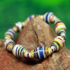 a multicolored bracelet sitting on top of a rock