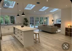 an open kitchen and living room with skylights