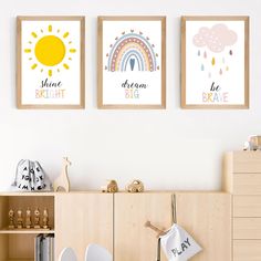 three children's wall art prints in a child's room with wooden cabinets