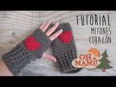 a pair of crocheted gloves with red hearts on them