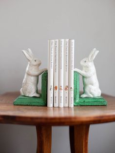 two bookends with rabbits on them sitting next to each other in front of a table