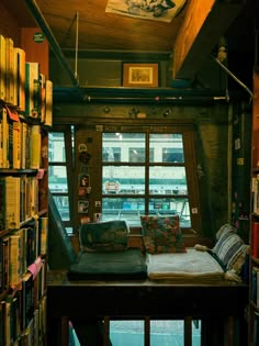 there is a small window in the corner of this room with bookshelves on both sides