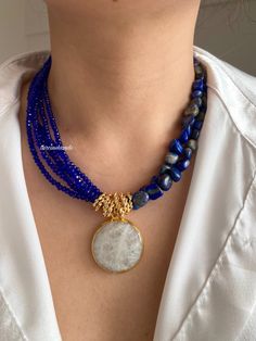 ✨ Gold-Plated Multistrand Necklace with Lapis Lazuli & Navy Glass Crystals - 16+2 inches Elevate your style with this Gold-Plated Multistrand Statement Necklace, showcasing a luxurious blend of Lapis Lazuli and navy-colored glass crystals. Designed for those who appreciate bold, elegant pieces, this necklace brings together the best of natural stones and refined materials. 💙 Lapis Lazuli & Glass Crystals: One half of the necklace features the rich blue hues of Lapis Lazuli, while the other half Stone Necklaces, Autumn Necklace, Lapis Lazuli Necklace, Necklace Chunky, Moonstone Pendant, Chunky Necklace, Multi Strand Necklace, Blue Gemstones, Gem Stone