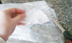 a person holding a plastic bag with scissors in the background