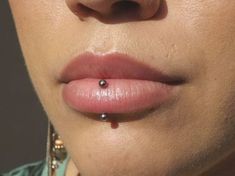 a woman with piercings on her lip and nose