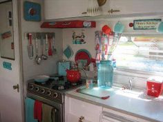 a stove top oven sitting inside of a kitchen next to a window with lots of magnets on it