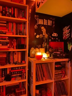 a room filled with lots of different types of records and movies on shelves next to a lamp