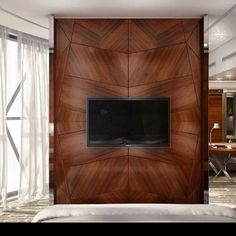 there is a tv mounted on the wall in this modern bedroom with wood paneling