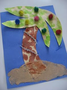 a paper plate with a palm tree on it and pom - poms around the leaves