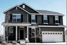 a two story house with black siding and white trim on the front door is shown