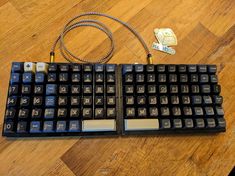 a black keyboard sitting on top of a wooden table