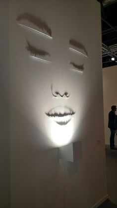 a white sculpture with eyes and eyelashes on it