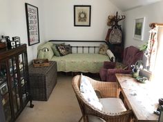 a living room with wicker furniture and pictures on the wall above the couches