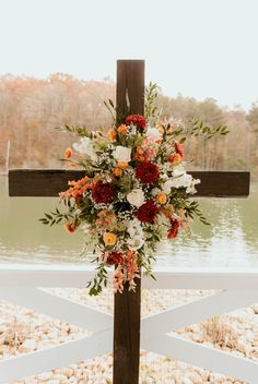 a cross decorated with flowers and greenery