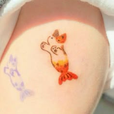 a woman with a tattoo on her arm that has a cat and fish on it