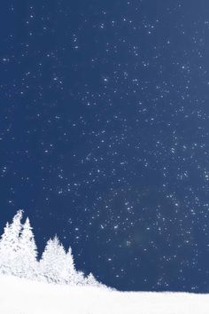 a person riding skis down a snow covered slope under a sky full of stars