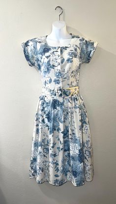 Add a touch of vintage charm to your wardrobe with this beautiful blue floral cotton dress from Hunt Club. Perfect for a casual occasion, this dress features a midi length and a cottagecore look that is sure to turn heads. The dress is made of cotton material and comes in a size 6 petite for women. The dress has a chest size of 32 inches, a waist size of 28 inches, and a shoulder to hem length of 43 inches. The blue & white color with a floral design make it a great choice for any vintage-loving fashionista. This original piece from the 1980s is a must-have for anyone who wants to add a unique touch to their wardrobe. Includes a wide matching belt, on the back of the belt is marked 6P which I believe means size 6 petite. This is unlined and machine washable. I found one very faint spot nea Tea Party Dress, Floral Cotton Dress, Hunt Club, Cosplay Props, Vintage Love, Chest Size, Dress Clothes For Women, Cotton Dress, Vintage Charms