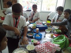 a group of children sitting around a table eating food