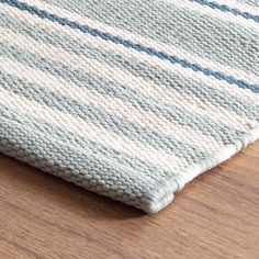 a close up of a rug on a wooden floor with a wood table in the background