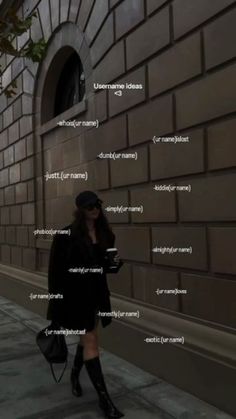 a woman is walking down the street with her cell phone in hand and text on the wall behind her