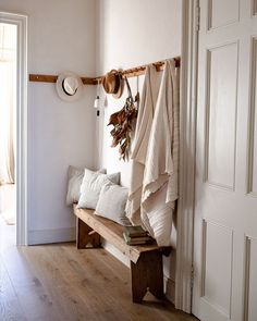 a wooden bench sitting next to a white door in a room with wood flooring