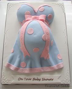 a blue and pink cake with polka dots on the top is for a baby shower