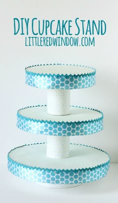 three tiered cake stand with blue polka dots on the bottom and white trim around it