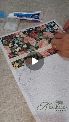 someone is cutting fabric with scissors on the table next to it and another item in the background