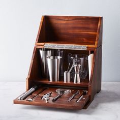 a wooden box with various kitchen utensils in it