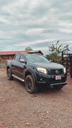 a black truck parked on top of a dirt field