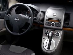 the interior of a car with steering wheel and dashboard controls