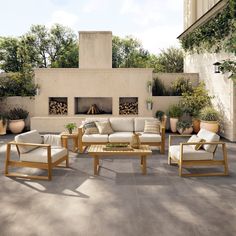 an outdoor living area with couches, tables and chairs in front of a fireplace