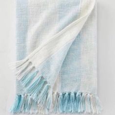 a light blue and white throw with fringes