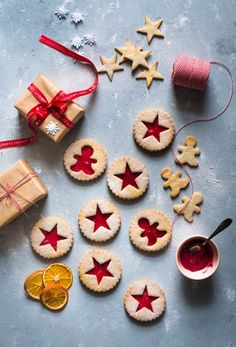 cookies decorated with red and white stars are on a table next to some orange slices