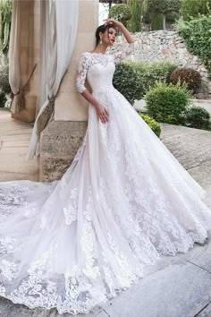 a woman in a white wedding dress posing for the camera with her hand on her head