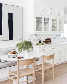 the kitchen is clean and ready for us to eat in it's white cabinetry