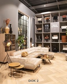 a living room filled with lots of furniture next to a book shelf full of books