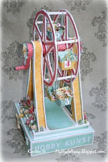 a wooden toy ferris wheel sitting on top of a blue and white table cloth covered wall