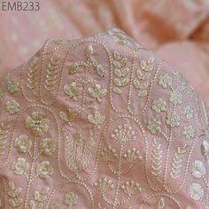 closeup of pink and gold embroidered fabric with white flowers on the top, as well as an emb23353