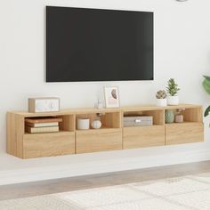 a tv mounted on the side of a wall next to a plant and bookshelf