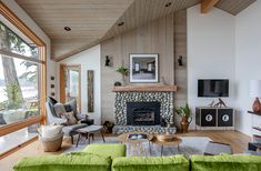 a living room filled with furniture and a fire place in front of a large window