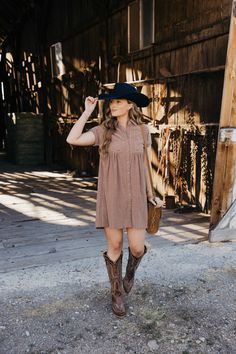 Introducing The Zuri Dress, a playful knee-length western dress in a gorgeous rust color. Made from textured fabric, this dress features a flattering fit and flare silhouette with short sleeves and a v neckline. Complete with a collared button down design and pocket detail, it's the perfect dress for fall fun! Haylee is wearing size small paired with the Ariat Casanova Boots, Felt Cowboy ProHat and The Talia Bag