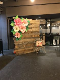 a wooden wall with flowers on it and two chairs